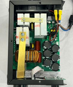 Internal view of a power supply board with large cooling fins, a copper coil, multiple capacitors, and assorted wiring.